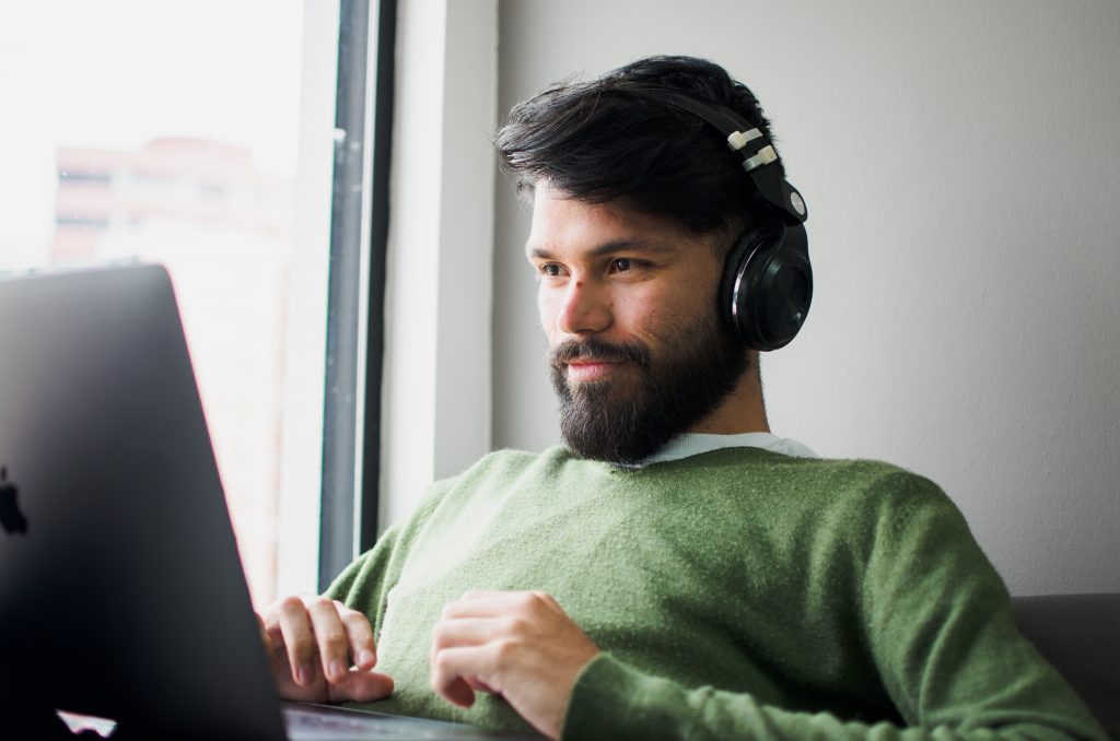 Hombre con auriculares mirando si sus traducciones públicas portugués-español ya se encuentran cotizadas